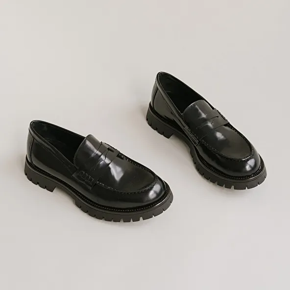 Moccasins with notched soles in glazed black leather